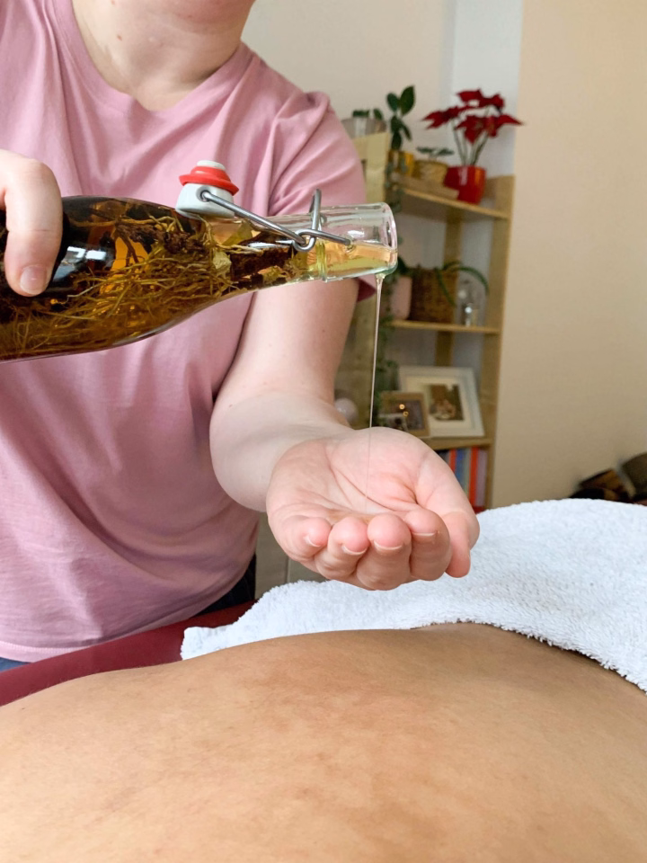 Person pouring oil onto towel in massage setting