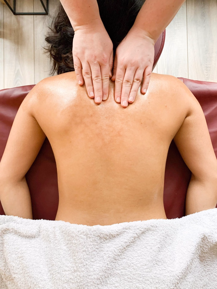 Person receiving Ayurvedic massage in a cozy setting