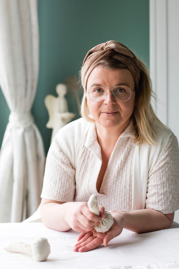 Magda holding herbal stamp as a part of her treatment